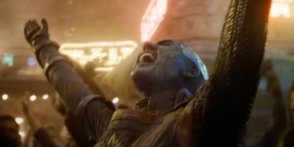 Nebula throwing her arms in the air in celebration during a scene from Guardians of the Galaxy Vol. 3.