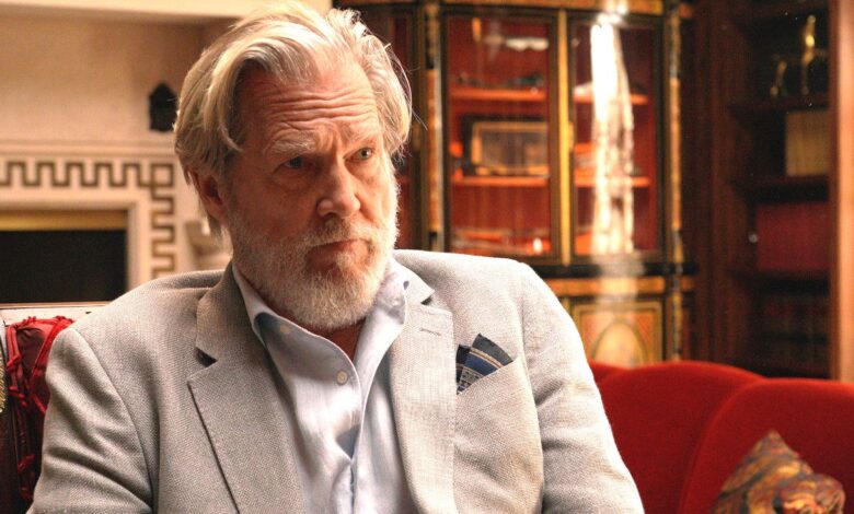 Jeff Bridges in The Old Man sitting in a chair in a lavish room looking scruffy