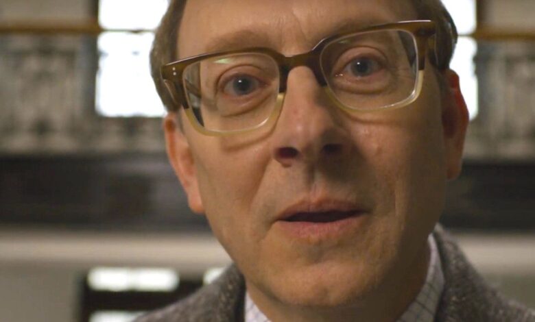 Michael Emerson as Leland in Evil wearing big thick glasses and talking straight into the camera, uncomfortably close to the lens