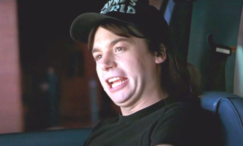 Mike Myers as Wayne in Wayne's World making a funny face while sitting in a car singing along to the Queen song Bohemian Rhapsody