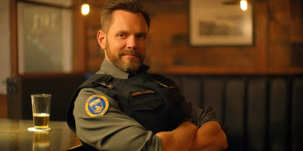 Joel McHale at Frank Shaw with his arms folded in Animal Control