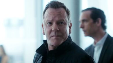 Kiefer Sutherland as John Weir standing in front of windows in Rabbit Hole