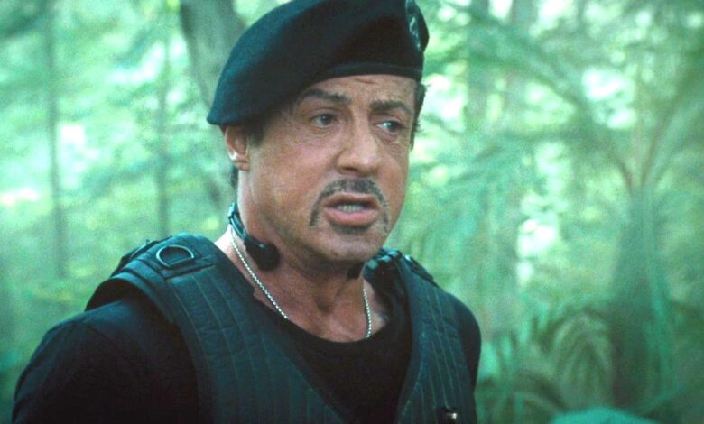 Sylvester Stallone in The Expendables wearing a flak jacket and beret in the jungle