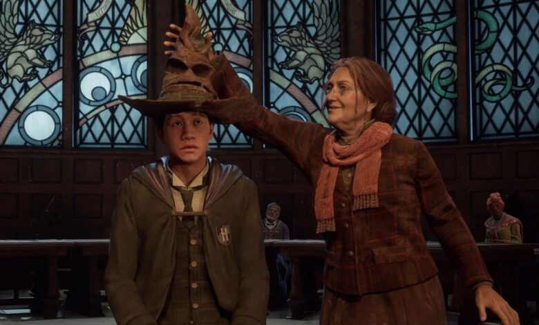 Hogwarts Legacy student having the sorting hat placed on him by a teacher.