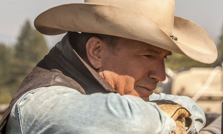 Kevin Costner with his head on top of a ranch fence in Yellowstone