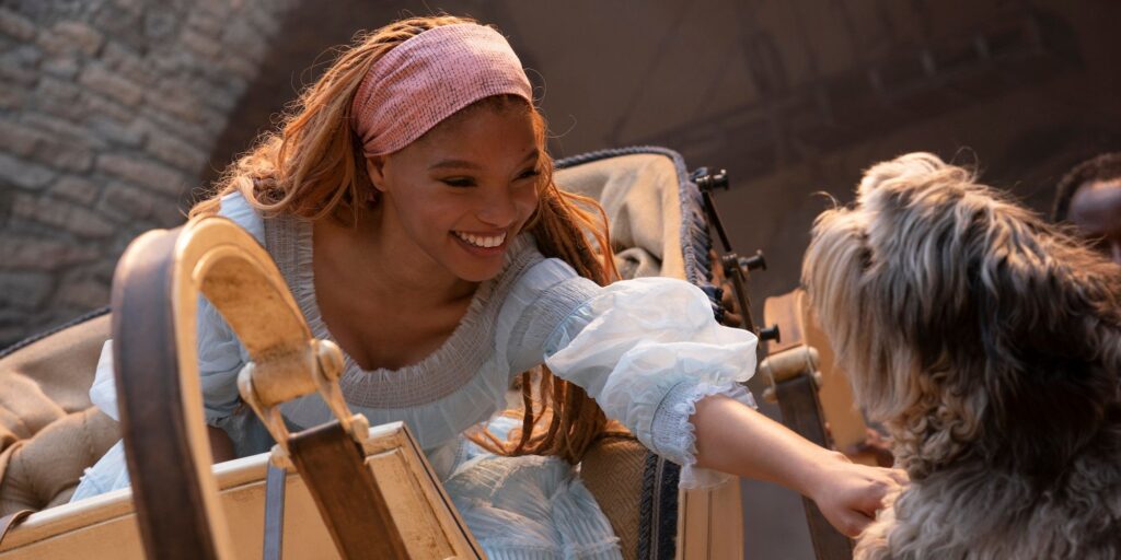 Ariel petting Max the dog while human in The Little Mermaid (2023)