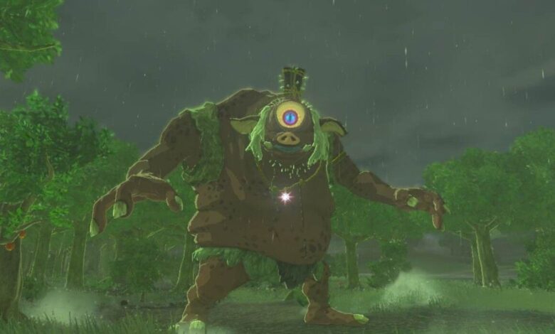 A red Hinox spots the player on a rainy day in Hyrule, staring at the camera in Zelda: Tears of the Kingdom