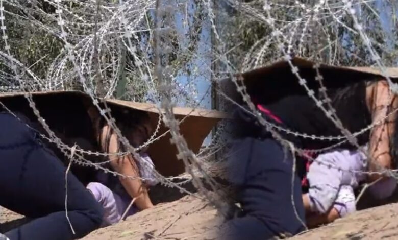 Video | Mujer con bebé cruza alambre de púas hacia EU; se protegen con un cartón
