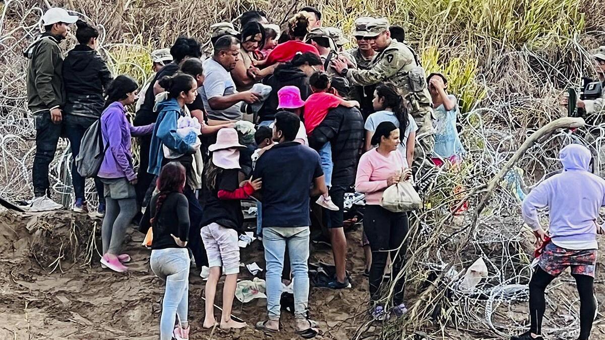 Migrantes abren hueco en alambrada, derriban a oficiales y entran a EU