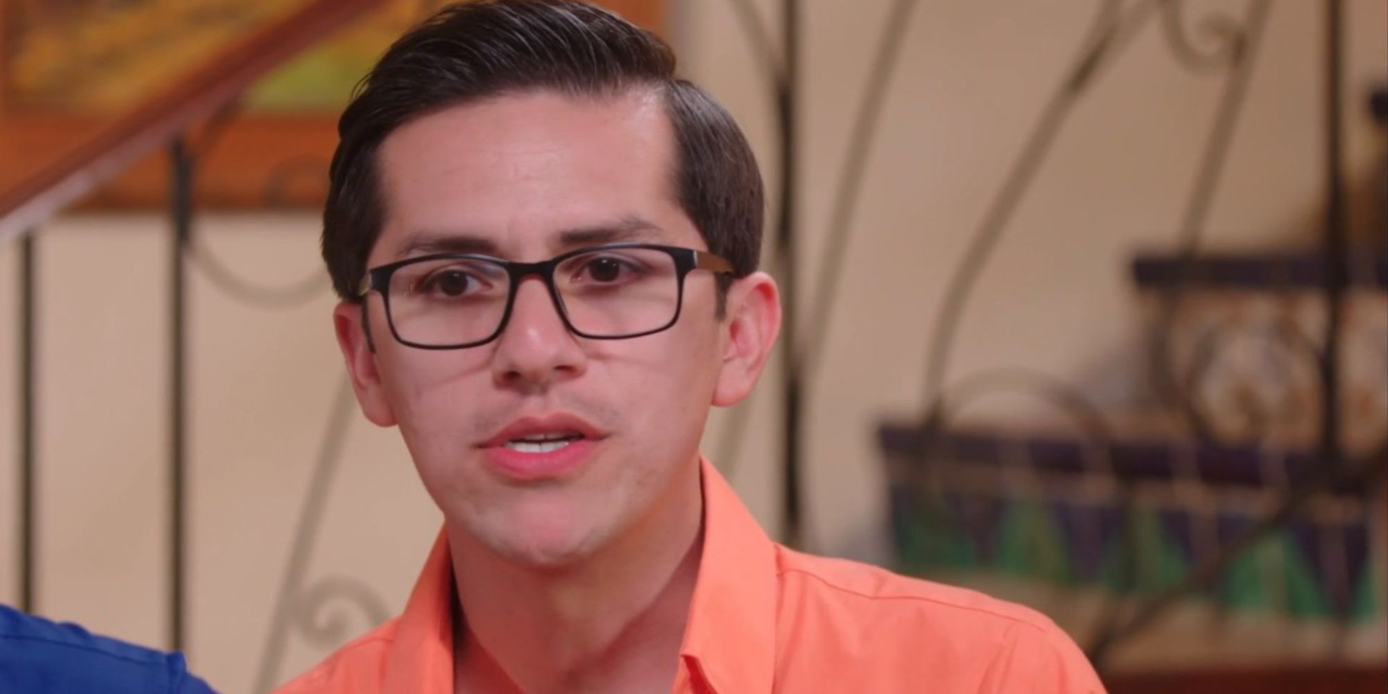 Armando Rubio de Prometido de 90 días The Other Way con camisa naranja hablando