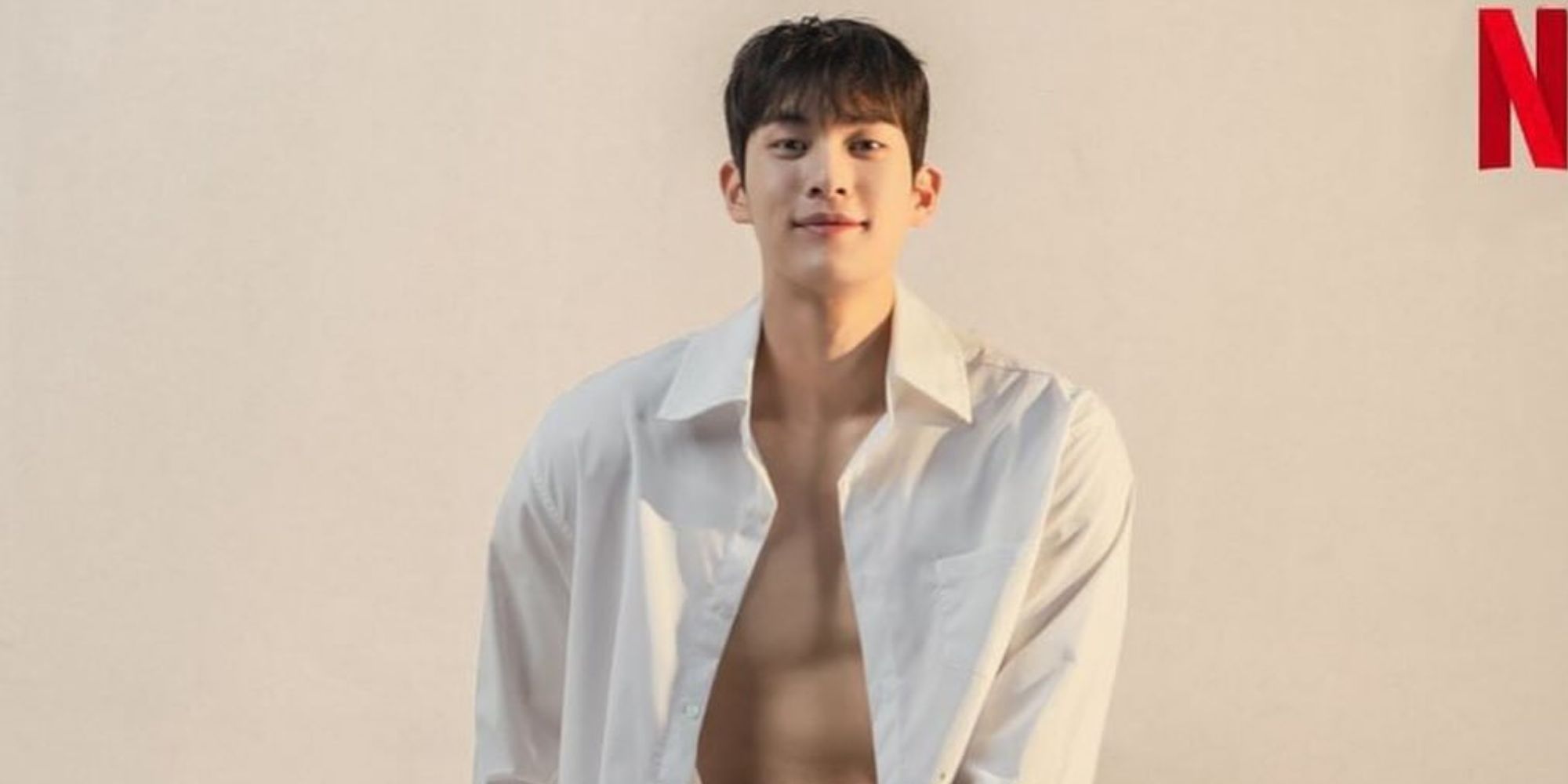 Choi Min-woo sentado, camisa abierta