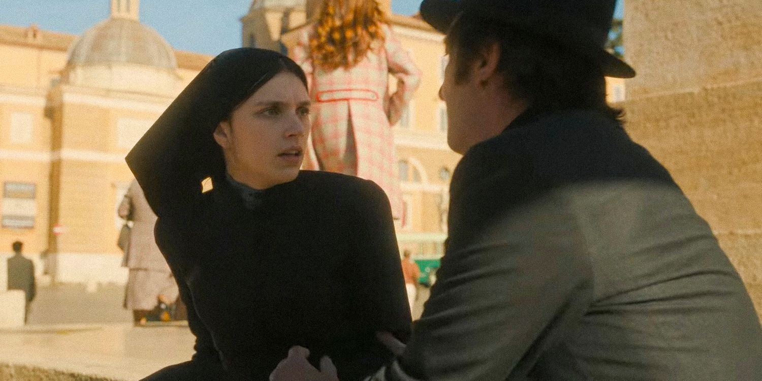 El padre Brennan sostiene el brazo de Margaret mientras habla con ella en The First Omen