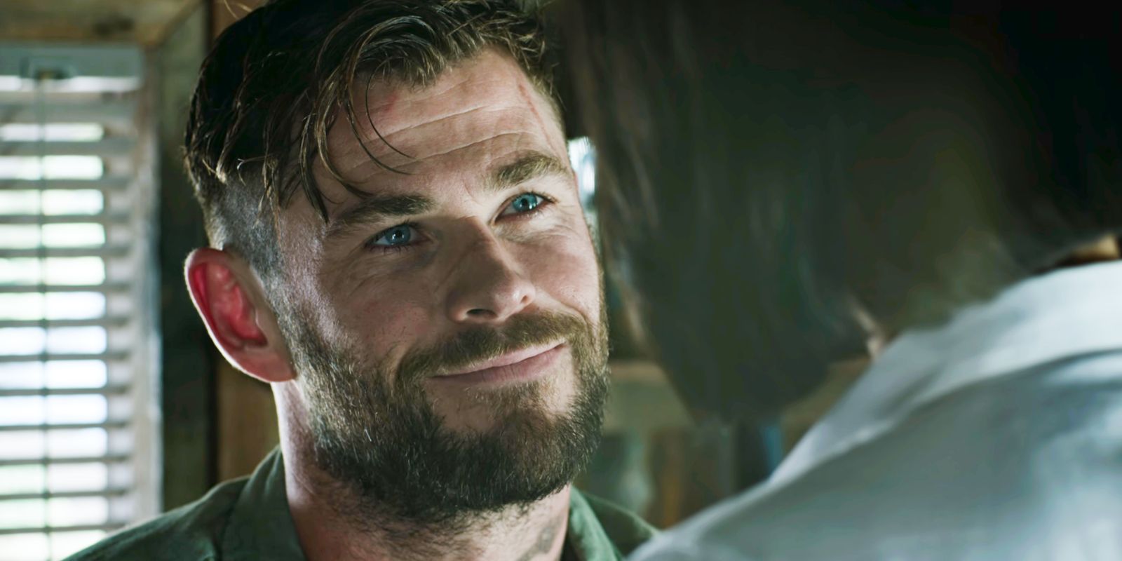 Tyler Rake de Chris Hemsworth sonriéndole a Nik en Extraction