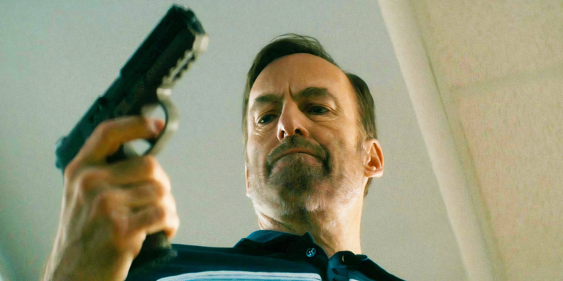 Bob Odenkirk sosteniendo una pistola como Hutch Mansell en Nadie
