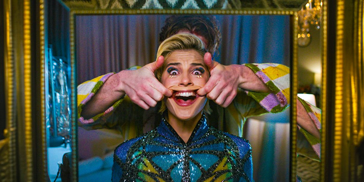 Alguien sosteniendo la boca de Skye Riley (Naomi Scott) en una sonrisa desde atrás mientras ella parece aterrorizada en Smile 2.