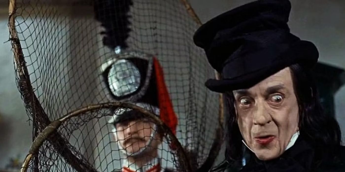 The Child Catcher mirando hacia un lado mientras sostiene una red en Chitty Chitty Bang Bang