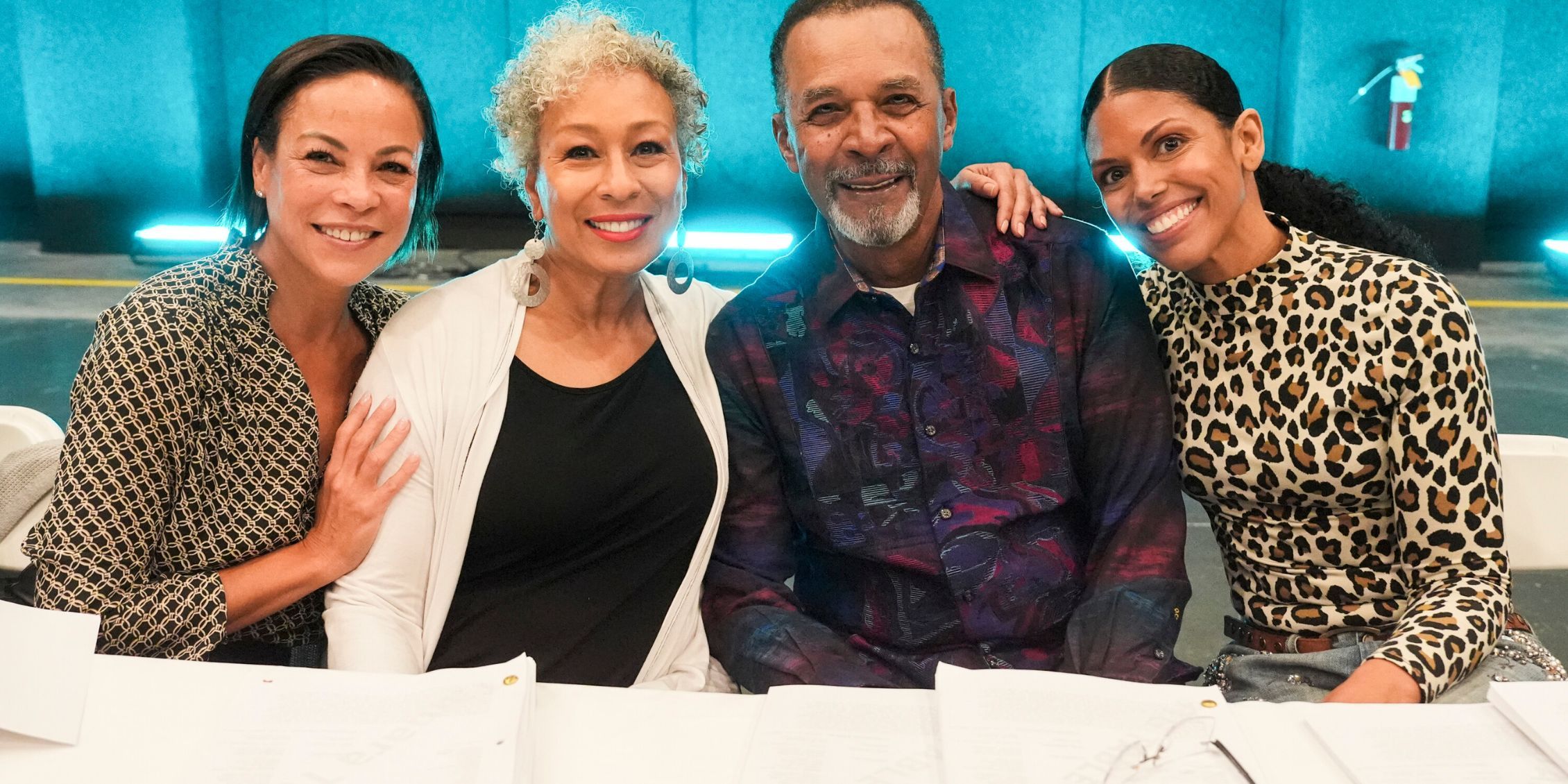 Tamara Tunie de pie y sonriendo en una mesa leída para Beyond The Gates