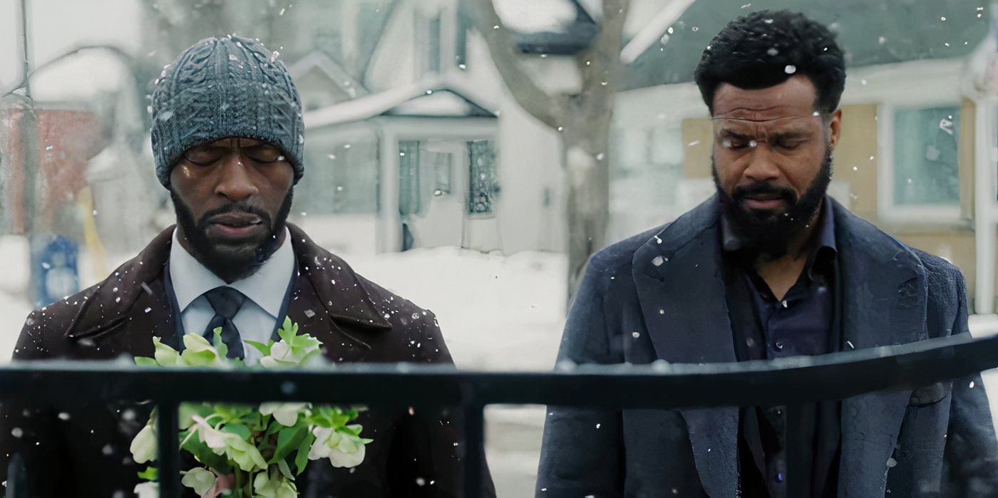 Aldis Hodge como Alex Cross visitando la tumba de su esposa con flores en Cross