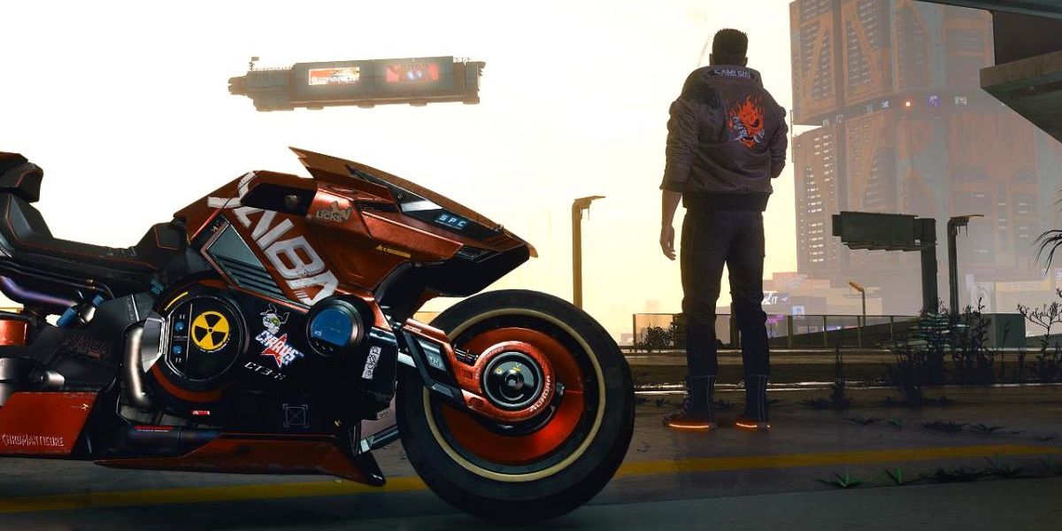 Un jugador en Cyberpunk 2077 de pie en la calle con su motocicleta a la vista.