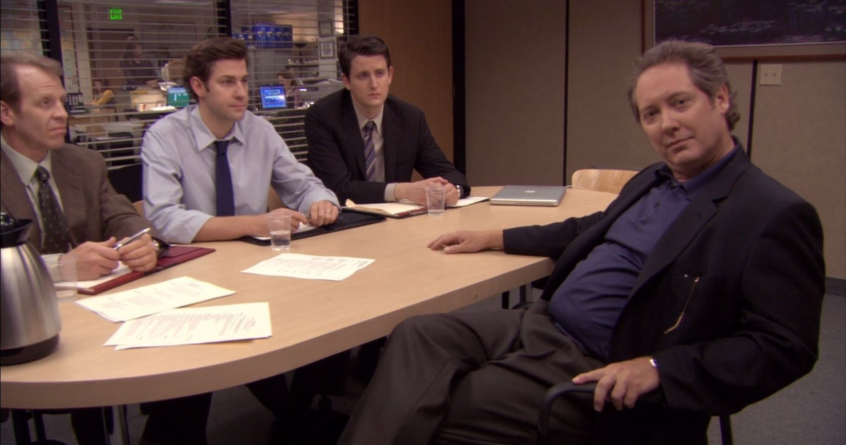 Robert California, mirando a la cámara mientras está siendo entrevistado por Toby, Jim y Gabe en el episodio de la temporada 7 de la oficina "Comité de búsqueda".