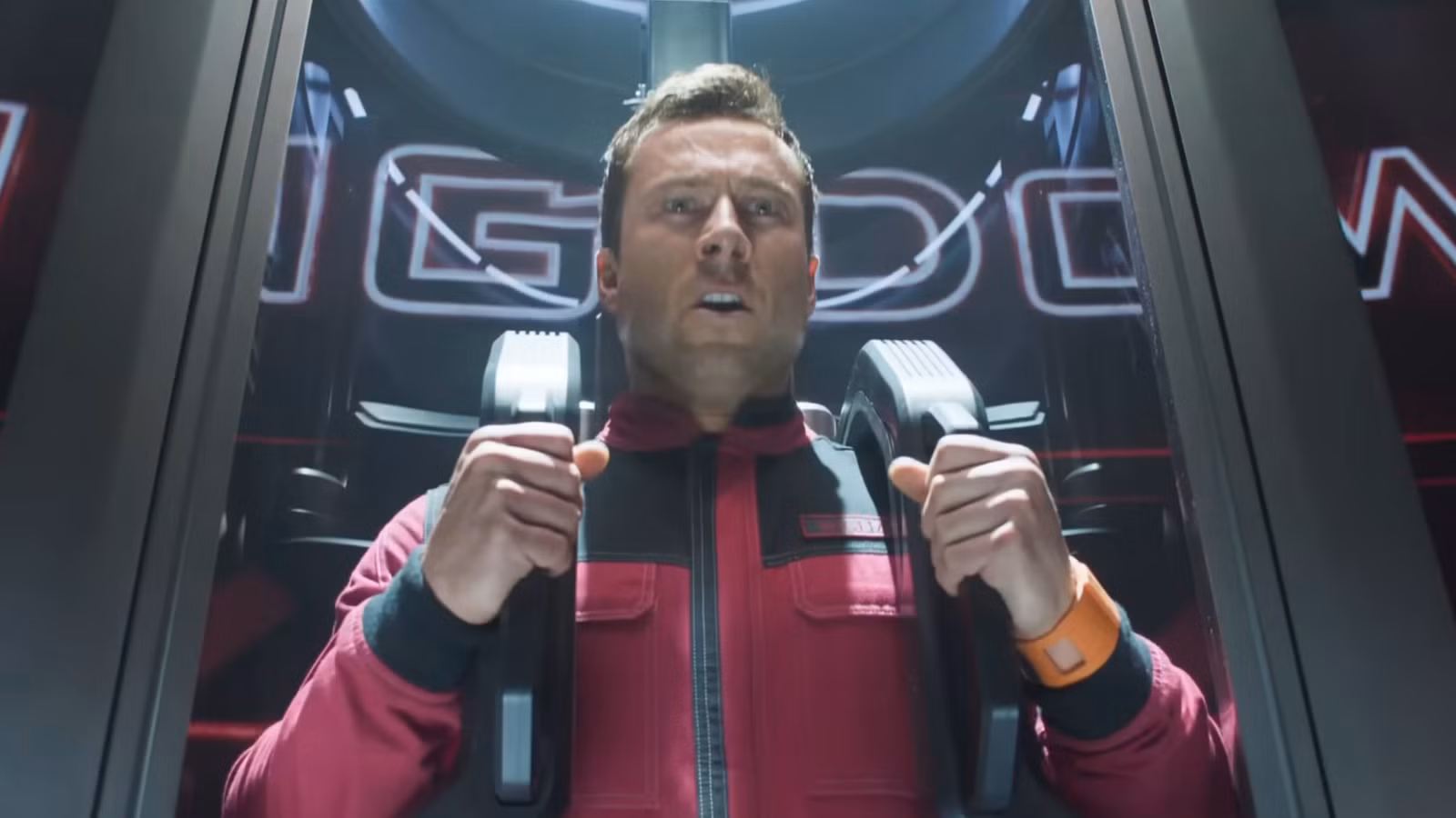 Richards hace una mueca mientras se prepara para ser lanzado por un tubo en The Running Man