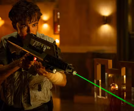Alex Lawther apuntando con un arma en Alien Earth