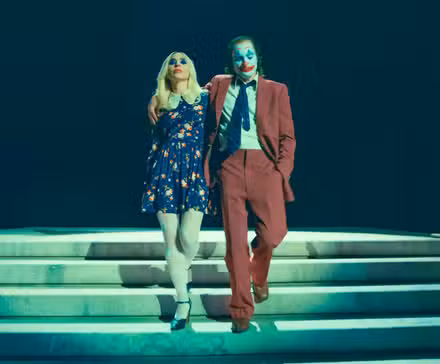 Harley Quinn (Lady Gaga) y Joker (Joaquin Phoenix) en actitud arrogante saliendo de la corte en Joker: Folie à Deux