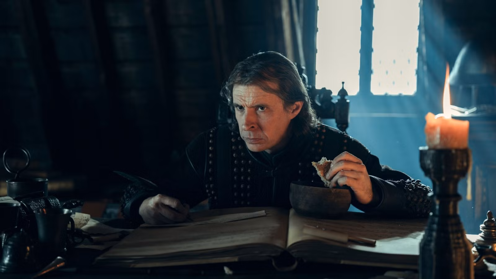 Plummer (Tom Vaughan-Lawlor) comiendo y tomando notas en Un Caballero de los Siete Reinos.