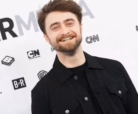 Daniel Radcliffe sonriendo en la alfombra roja de WarnerMedia