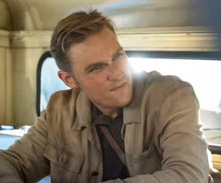 Wyatt Russell como el joven Lee Shaw sonriéndole a alguien en Monarch: Legacy of Monsters.