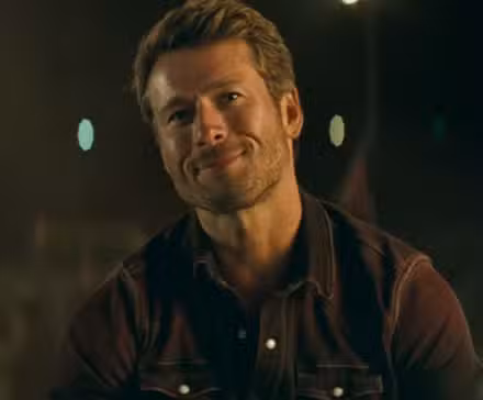 Glen Powell con media sonrisa en Twisters