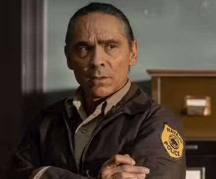 Zahn McClarnon como Joe Leaphorn, cruzado de brazos, en un episodio de Dark Winds