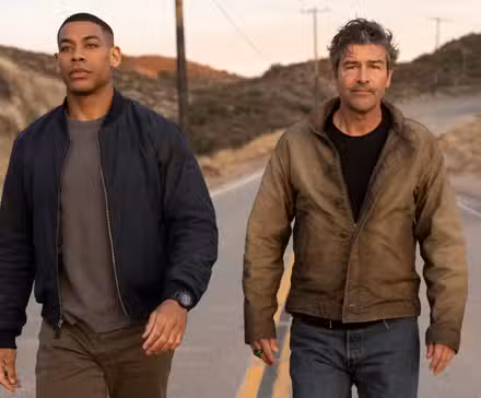 Aaron Pierre y Kyle Chandler caminando por una calle en Lanterns