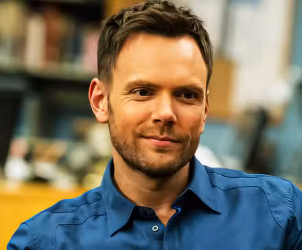 Joel McHale como Jeff Winger sentado en la sala de estudio de Community.