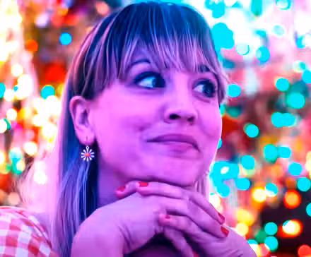 Kaley Cuoco con la cabeza entre las manos luciendo intrigada en Meet Cute