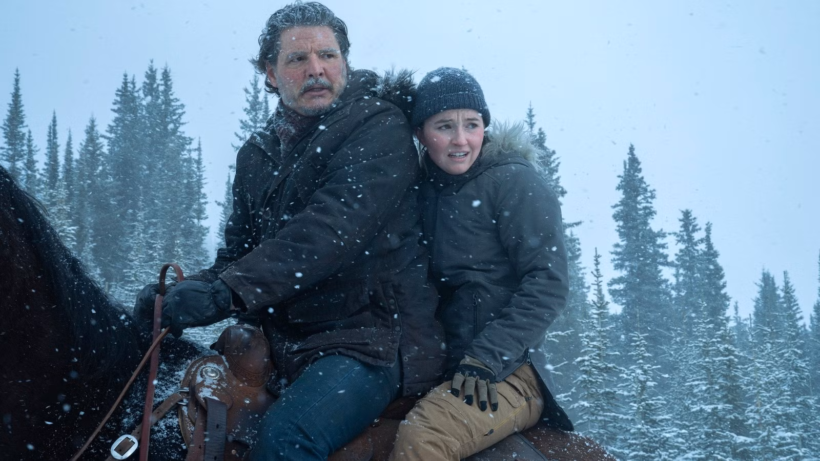 Joel (Pedro Pascal) y Abby (Kaitlyn Dever) montando a caballo durante una tormenta de nieve en la temporada 2 de The Last of Us