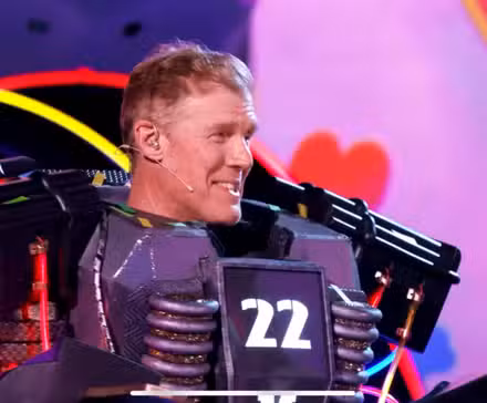 El concursante de la temporada 14 del cantante enmascarado Alexi Lalas (Alto voltaje) sonriendo después de ser desenmascarado