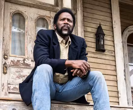 Boyd sentado en el porche de Colony House en la temporada 4