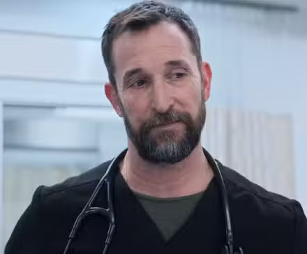 Noah Wyle como Robby, mirando hacia abajo en un episodio de la temporada 2 de The Pitt