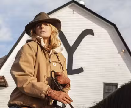 Kelly Reilly como Beth Dutton montando a caballo frente al rancho de Yellowstone en Yellowstone