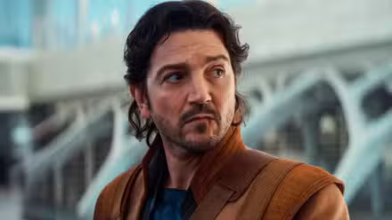 Cassian Andor mira de reojo a alguien fuera de la pantalla