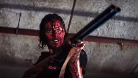 Lily Sullivan sosteniendo un arma en Evil Dead Rise.