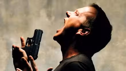 Kiefer Sutherland como Jack Bauer gritando y sosteniendo un arma en 24
