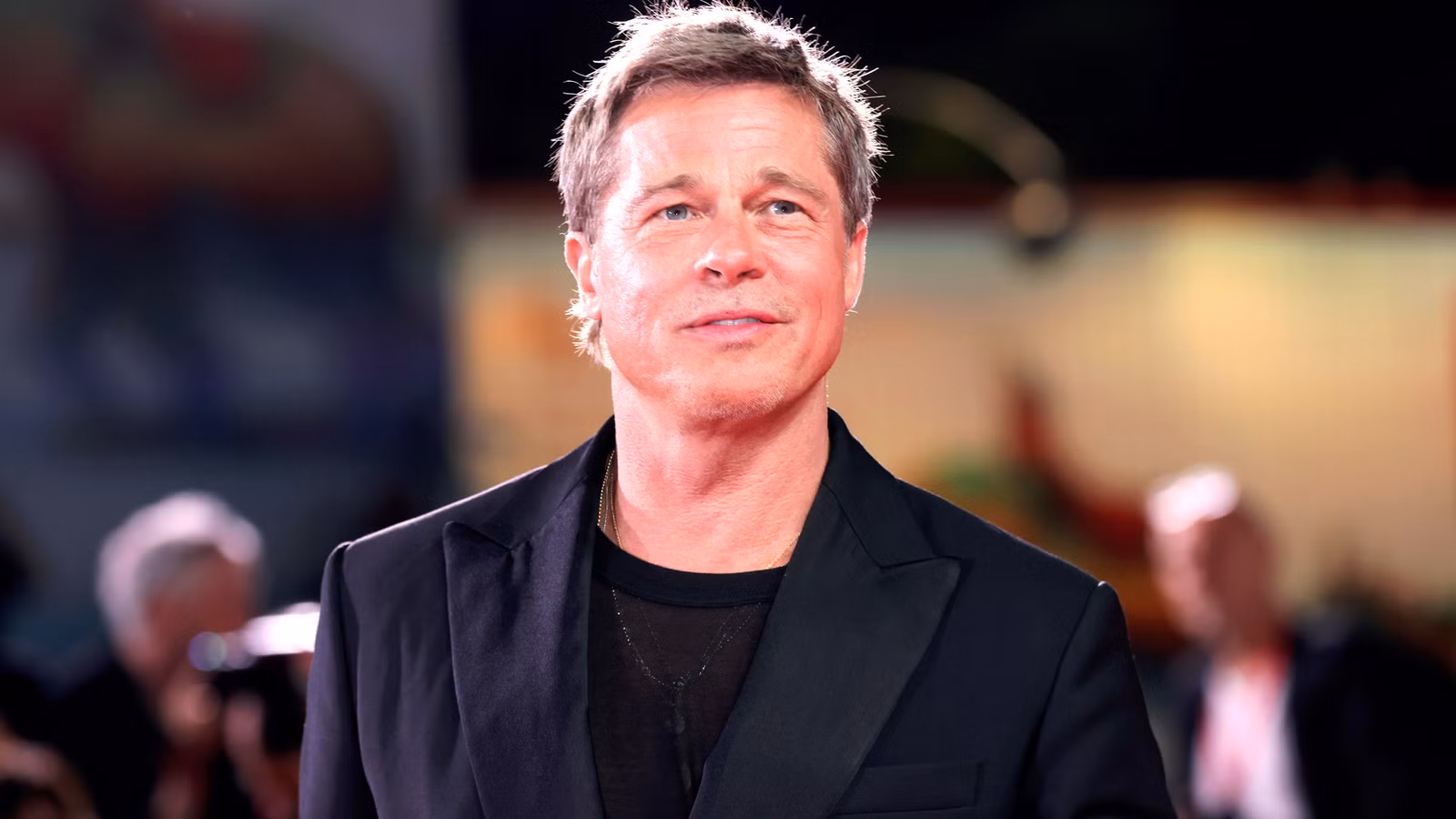 Brad Pitt sonriendo en la alfombra de Wolfs del Festival de Cine de Venecia