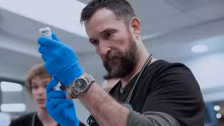 Noah Wyle como Robby sacando una jeringa en la temporada 2 de The Pitt