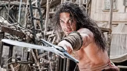 Jason Momoa como Conan el Bárbaro, apuntando con una espada hacia adelante.