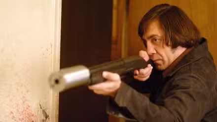 Javier Bardem como Anton Chigurh blandiendo una escopeta con silenciador en No es país para viejos