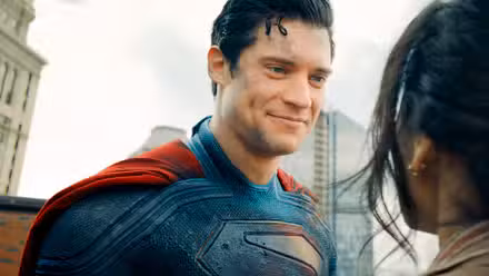 Superman de David Corenswet sonriéndole a una mujer que acaba de salvar en la película de DCU