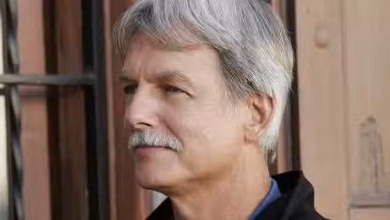 Mark Harmon como Gibbs en NCIS, mirando hacia adelante y sonriendo