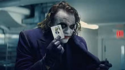 Heath Ledger como el Joker sosteniendo un naipe en The Dark Knight